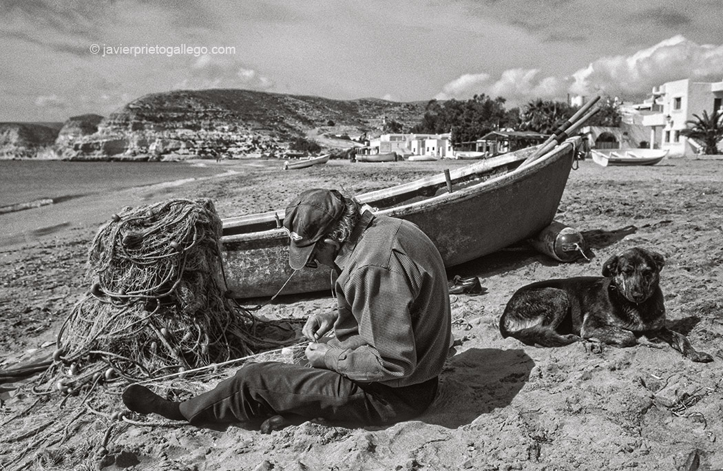 Un pescador repara sus redes sobre la arena de la playa de Agua Amarga. Cabo de Gata. Almería. España, marzo de 1999 © Javier Prieto Gallego