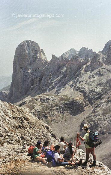 Un grupo de jóvenes montañeros contemplan la estampa del Naranjo de Bulnes (2.519 m) en su camino hacia Torre Bermeja (2.400 m) Castilla y León. España. © Javier Prieto Gallego
