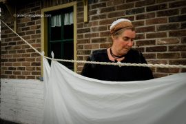 Una mujer lava a mano y tiende la ropa en el barrio de pescadores del museo al aire libre de Zuiderzee Museum, en Enkhuizen, en la región de Noord Holland, Holanda, 2005 © Javier Prieto Gallego